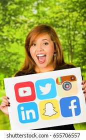 Quito, Ecuador - March 11, 2016: Happy Woman Holding A Printed Stickers Of Facebook, Youtube, Snapchat, Twitter, Instagram And Linkedin Icons, The Most Used Aplication In The World With Both Hands In