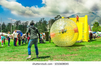 QUITO, ECUADOR - NOVEMBER 28, 2017: Outdoor View Of Unidentified Young People Inside Of Giant Inflatable Transparent Ball Sliding In A Plastic Slide In The Carolina Park During A Festival In The City