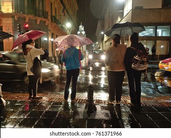 Quito, Pichincha, Ecuador - 2019: People Wait To Cross A Street In The Historic Center On A Rainy Night.