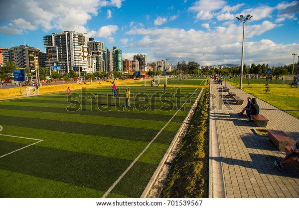 Quito, Pichincha Ecuador -\
August 10 2017: Unidentified people playing soccer inside of the\
Carolina park north part of the city of Quito, in a sunny day, blue\
sky