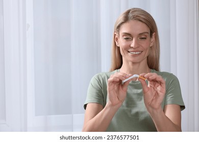 Quitting smoking concept. Happy woman breaking cigarette on light background. Space for text - Powered by Shutterstock