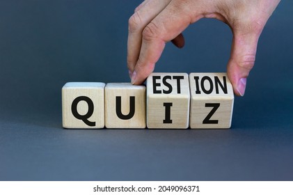 Quiz or question symbol. Businessman hand turns cubes and changes the word 'quiz' to 'question'. Beautiful grey background. Business quiz or question concept. Copy space.
