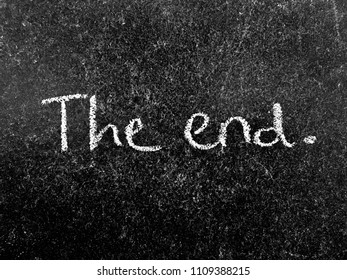 The quote “The end” written with white chalk on a black chalkboard