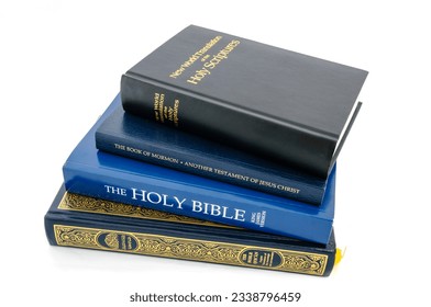 A Quran, a Holy Bible, a Book of Mormon and the New World Translations of the Holy Scriptures pied up