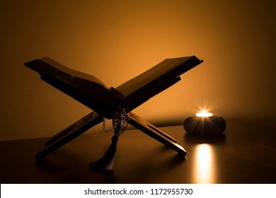 Quran and rosary beads on the white background with blue candle for Islamic concept. Holy book Koran for Muslims holiday, Ramadan,blessed Friday message and three months