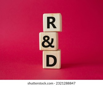 R and D - research and development symbol. Wooden cubes with word R and D. Beautiful red background. Business and R and D concept. Copy space.