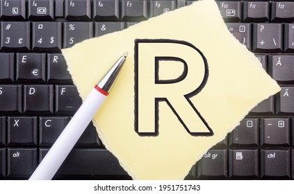 R Programming Language. Letter R On Paper And Laptop