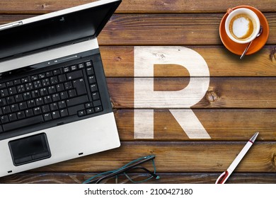 R Programming Language. Letter R On Wooden Desk And Laptop 