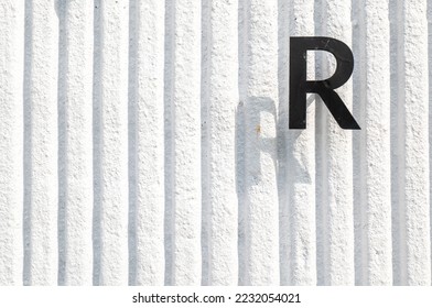 R text on white wall background, R stamp on white wall, consonant R on white wall. - Shutterstock ID 2232054021