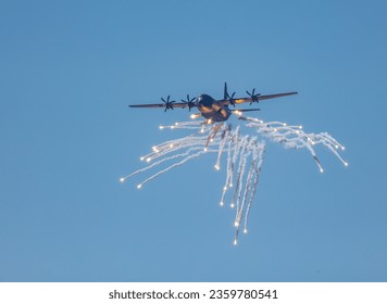 A RAAF Hercules transport airplane shooting out flares for protection from missiles at an airshow on the Gold Coast of Australia. - Powered by Shutterstock