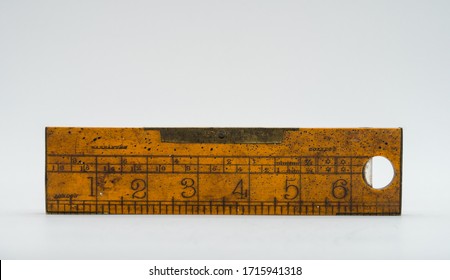 Raasiku / Estonia - April 25 2020: Antique carpenter's boxwood ruler with metallic sides from 19th century with brass level on one side, isolated on white. Marked as Warranted, Correct and London