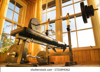 Raasiku/Estonia-05.01.2020: Home Gym On Balcony. Amazing Warm Sun Light. Weights Set And Bench Press In Home Gym. Home Office And Work Out Station.