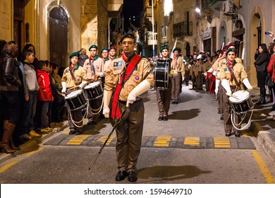 RABAT, MALTA - Mar 29, 2013: Members of the 1st Rabat Scout Group, baton carrying leader and band in front, participating in the Good Friday procession, Rabat, Malta