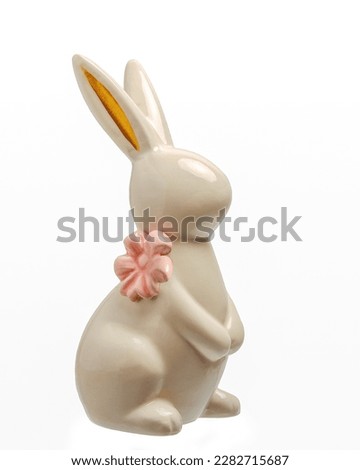   Rabbit with a pink bow, made of ceramics. Easter, decorative souvenir, for a gift and table decoration, isolated on a white background.