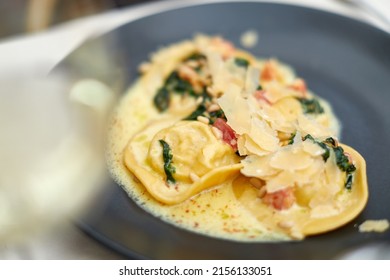rabbit ravioli in cream sauce with spinach, pine nuts and tomatoes