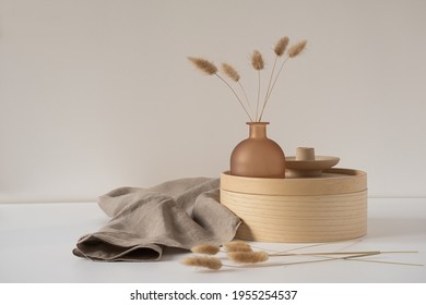 Rabbit Tail Grass In Beautiful Tan Vase, Wooden Storage Box, Neutral Beige Blanket Against White Wall. Aesthetic Minimal Hygge Interior Design Concept