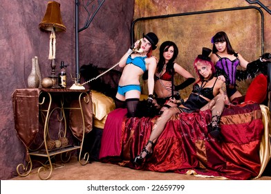 Rabble rousing group of burlesque dolls dancers gathered on the bed of their dressing room