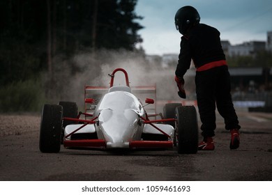 Race car is broken. Sad driver near broken vintage formula one at the race track. Old classic Formula 1 car in accident 