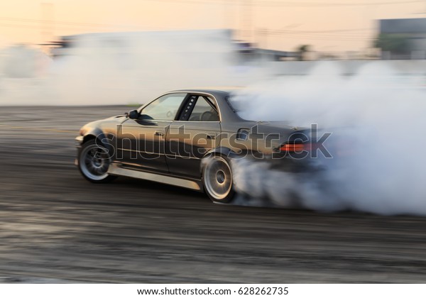 Race car drifting on speed track,\
Professional driver drifting car on race track with smoke, Abstract\
texture and background black tire tracks skid on asphalt road,\
Wheel tire tracks\
background.