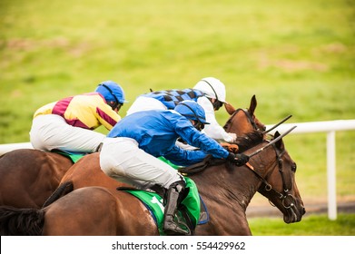 Race Horses And Jockeys Competing For First Place In A Race