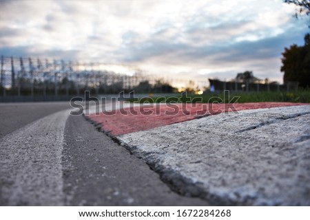 Race track corner close up. Red and white kerb and asphalt with sky