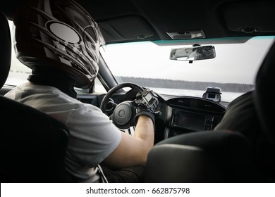 Racer In Black Helmet Drives Modern Sport Car With Action Camera On Hand During Competition At Winter