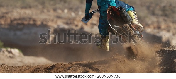 Racer\
boy on motorcycle participates in motocross race, active extreme\
sport, flying debris from a motocross in dirt\
track