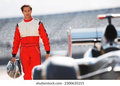Racer carrying helmet on track