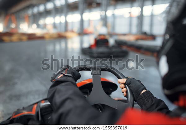 Racer in helmet driving go\
kart car