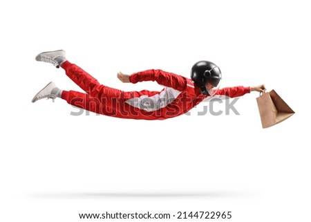 Racer in a red suit flying and carrying a fast food delivery bag isolated on white background 