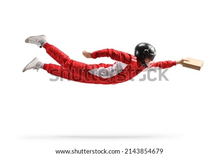 Racer in a red suit and a helmet flying and carrying a cardboard package isolated on white background 