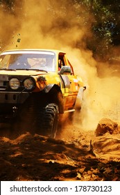 Racer At Terrain Racing Car Competition, The Car Try To Cross Extreme Off Road With Red Earth,  Wheel Make Splash Of Soil And Dusty Air, Competitor  Adventure In Championship Spirit 