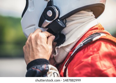 The Racer's Hand Is Wearing A Helmet Strap For Safety In The Race.