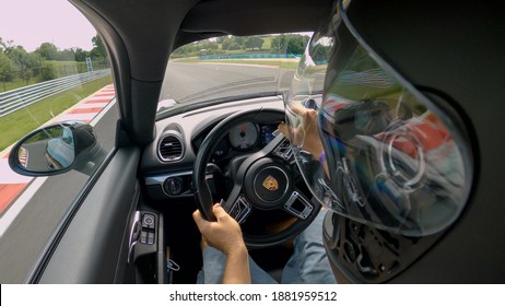 RACETRACK SLOVENIA, AUGUST 2020: CLOSE UP: Unrecognizable Man Races Along An Empty Asphalt Racetrack In A Porsche Sportscar. Driver Is Racing Down A Closed Circuit In A Racecar On A Cloudy Summer Day.