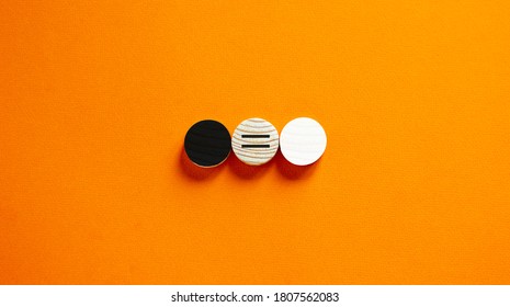 Racial Equality Concept. Black And White Wood Circles  On Beautiful Orange Background. Copy Space.