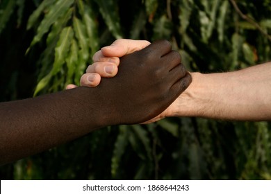 Racial Reconciliation And Harmony Represented By The Hand In Hand Of A Black Man And White Man