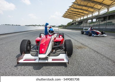 racing car driver celebrate victory sign in sepang f1 track 