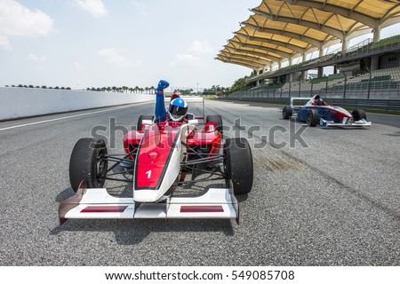 racing car driver celebrate victory sign in sepang f1 track 