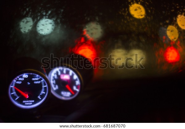 Racing car water temperature gauge in romantic\
rainy day with break light bokeh background concept for control\
display empty space advertising text, modern tuned panel, symbol of\
safety on the road.