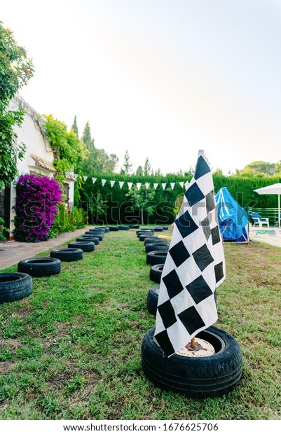 Racing circuit with tires in a\
patiotrasero for children to play races, with a checkered\
flag.