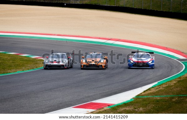 Racing GT cars group Mercedes AMG and Porsche 911\
challenging on asphalt track. Mugello, Italy, march 27 2022. 24\
Hours series
