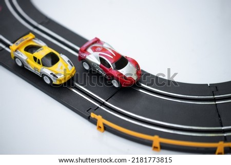 Racing on toy cars. Competition with rivals in the race. The red car overtakes the yellow one. Radio-controlled cars.
