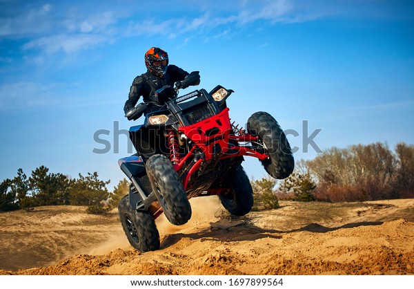 Racing powerful quad bike on the difficult sand\
in the summer.