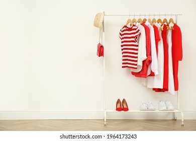 Rack with bright stylish clothes, shoes and accessories near white wall indoors, space for text - Shutterstock ID 1964173243