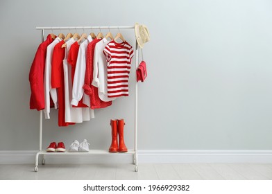 Rack with bright stylish clothes, shoes and accessories near light grey wall indoors, space for text - Shutterstock ID 1966929382
