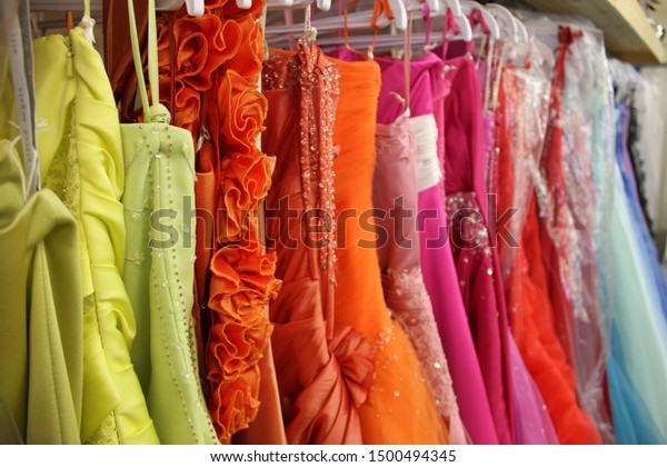 Rack of brightly\
coloured prom dresses