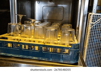 Rack of clean glasses placed inside a dishwasher.