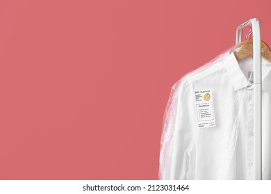 Rack With Clean White Shirt In Plastic Bag On Pink Background