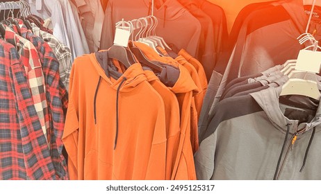 A rack of clothes with a plaid shirt hanging on the left - Powered by Shutterstock