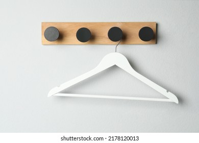 Rack with empty clothes hanger on white wall - Powered by Shutterstock